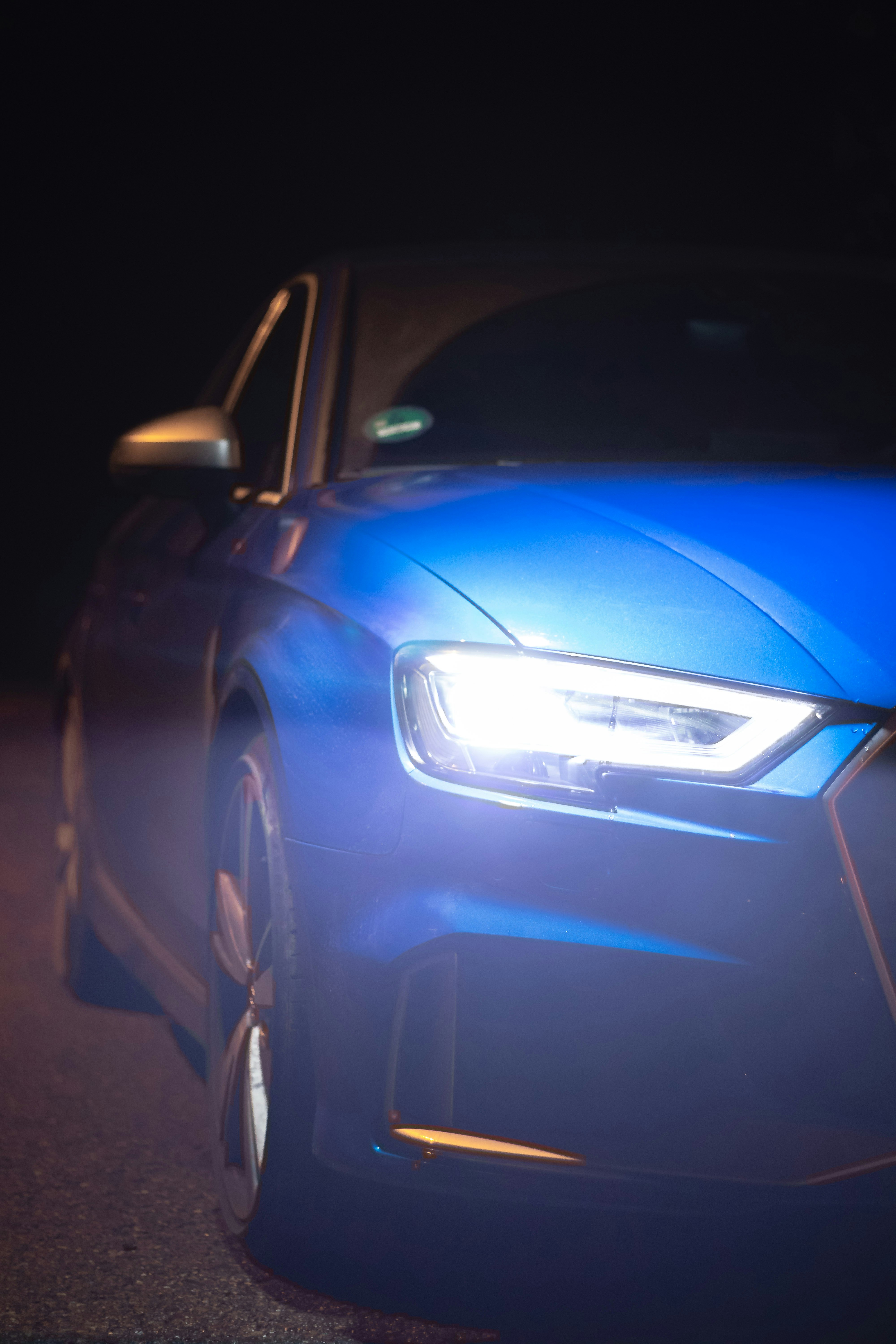 blue car on black asphalt road during night time